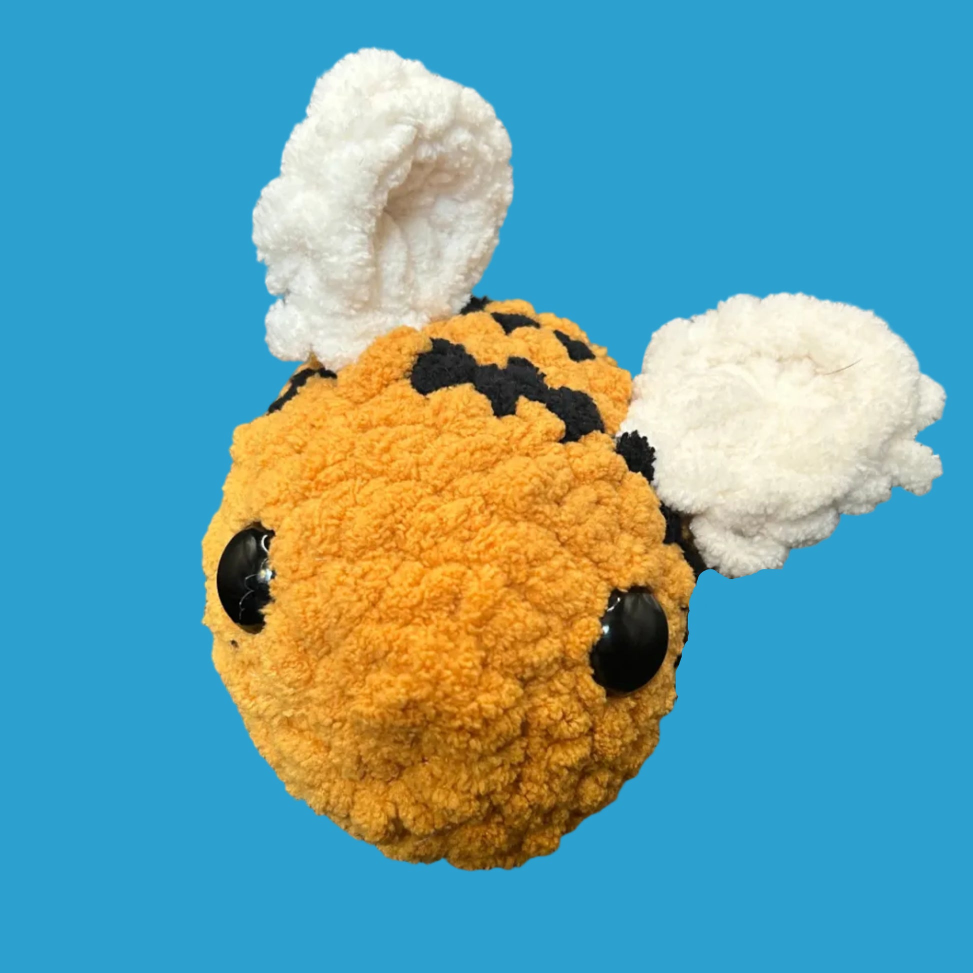 Small plush toy resembling a bee on a blue background